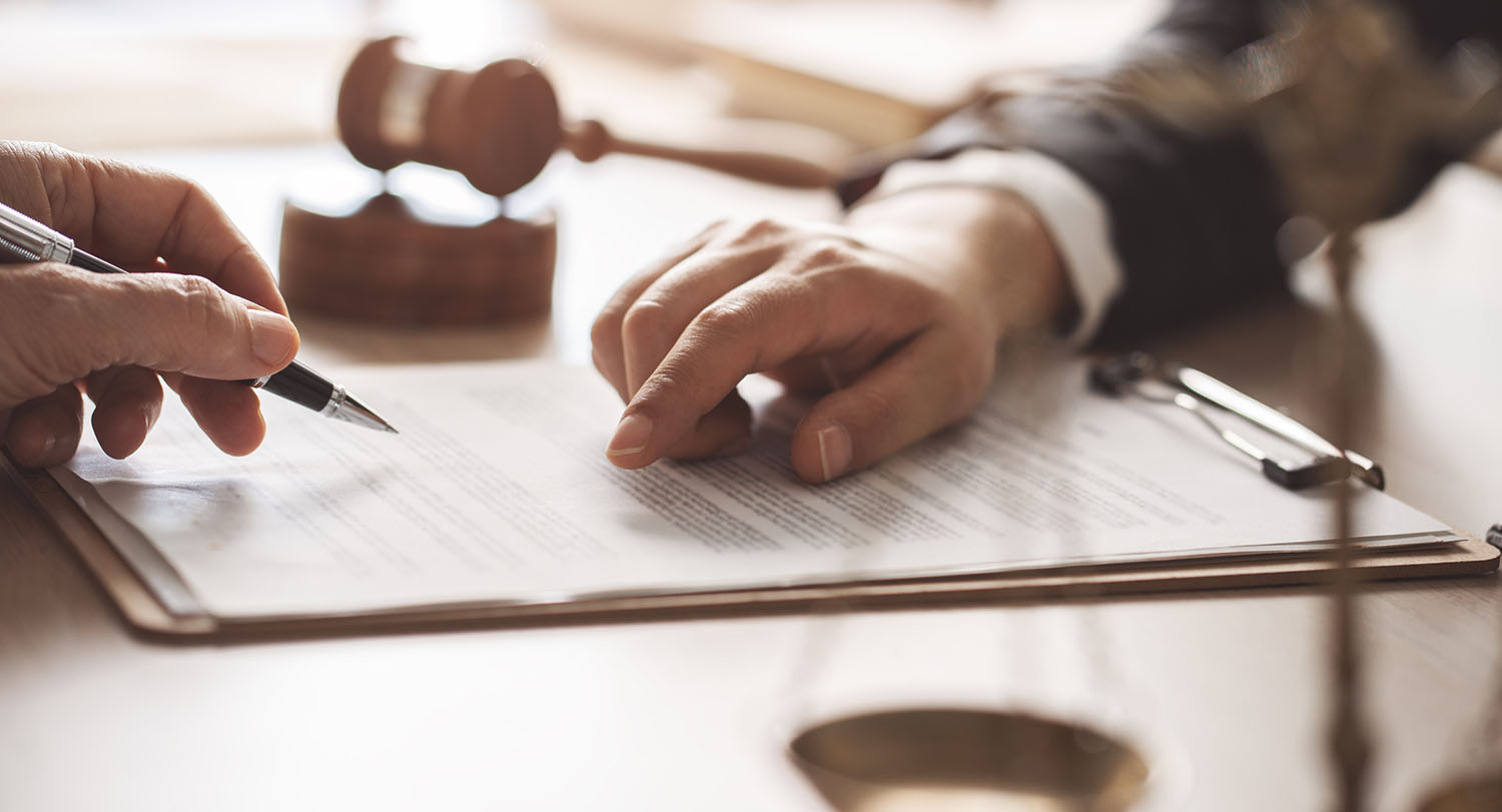 Hands working on a legal document.
